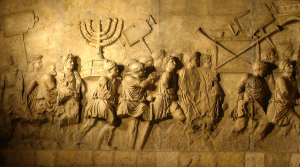 Commemorating the Roman siege of Jerusalem in 70 AD, this was constructed in 82 AD in Rome. The south panel depicts the spoils taken from the Temple in Jerusalem. The Golden Candelabra or Menorah is the main focus and is carved in deep relief. Other sacred objects being carried in the triumphal procession are the Gold Trumpets and the Table of Shew bread