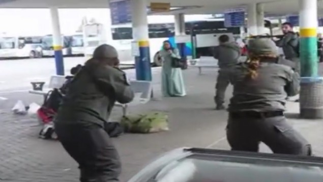 "A still image taken from cellphone footage of security forces surrounding a knife-wielding Israeli Arab woman after she allegedly tried to stab a security guard at Afula bus station on Friday, October 9, 2015. (screen capture)"