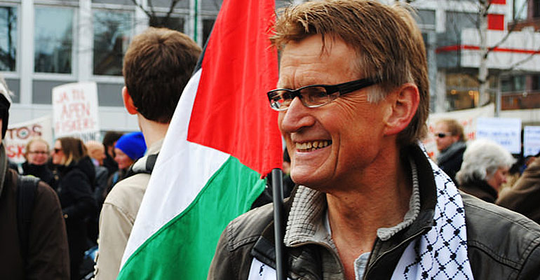 Mads Gilbert carrying a Palestinian flag