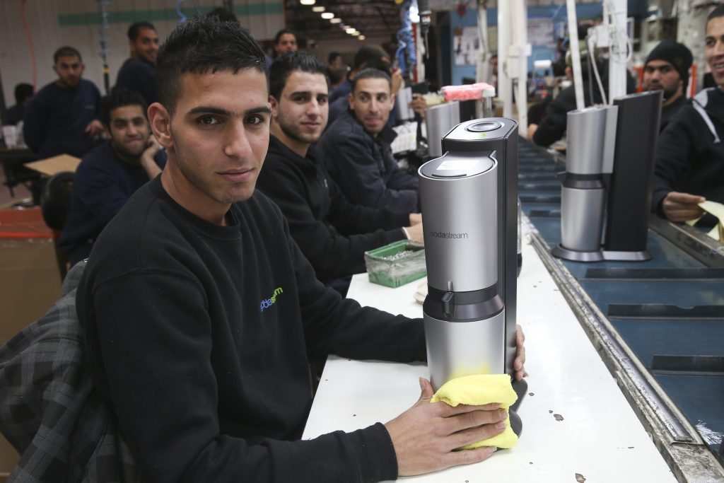 Palestinians work at a SodaStream factory on February 2, 2014 in the Mishor Adumim industrial park, next to the Maale Adumim. Photo by Nati Shohat/Flash90